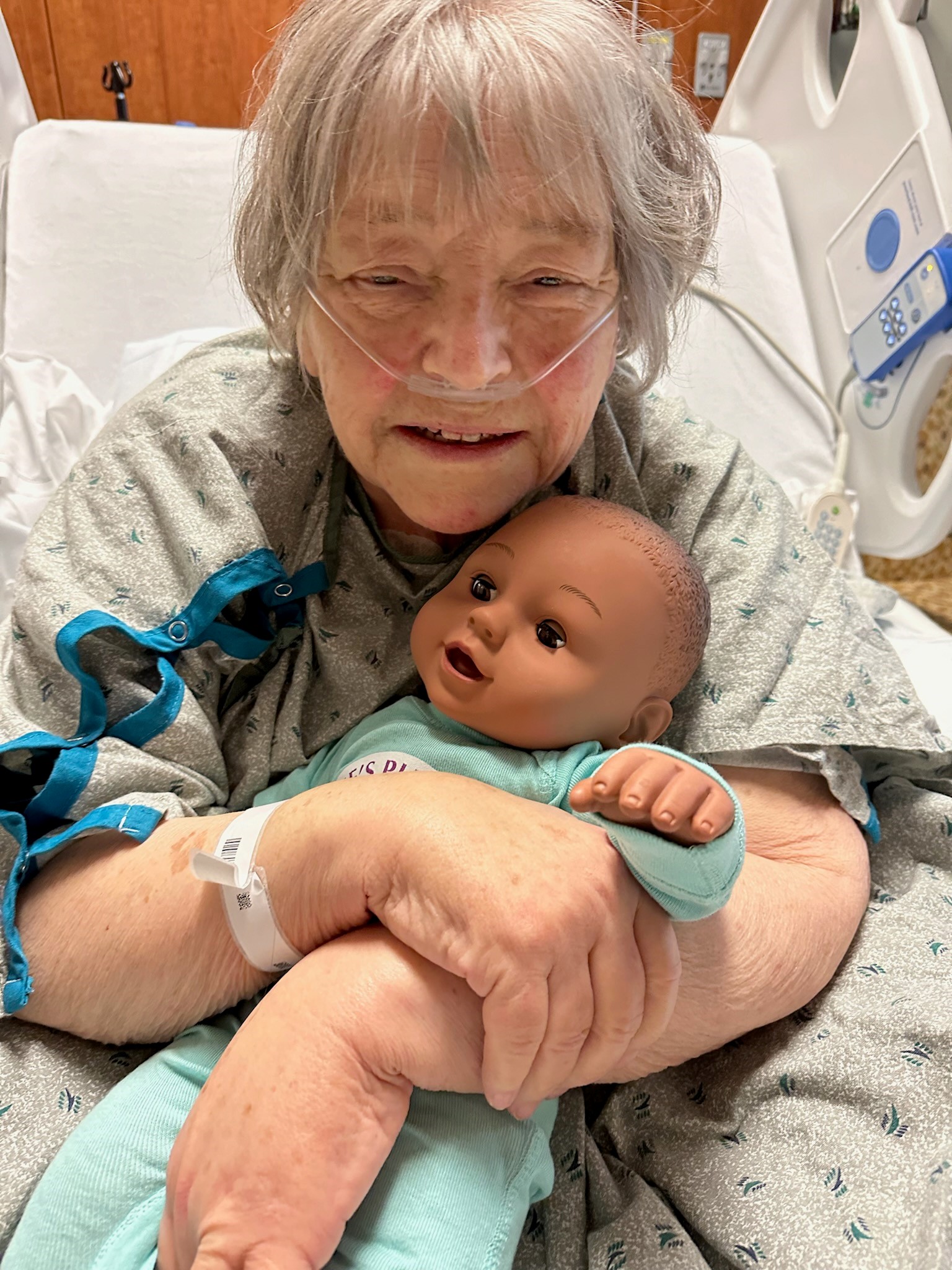 A patient holding a therapeutic doll in a hospital setting